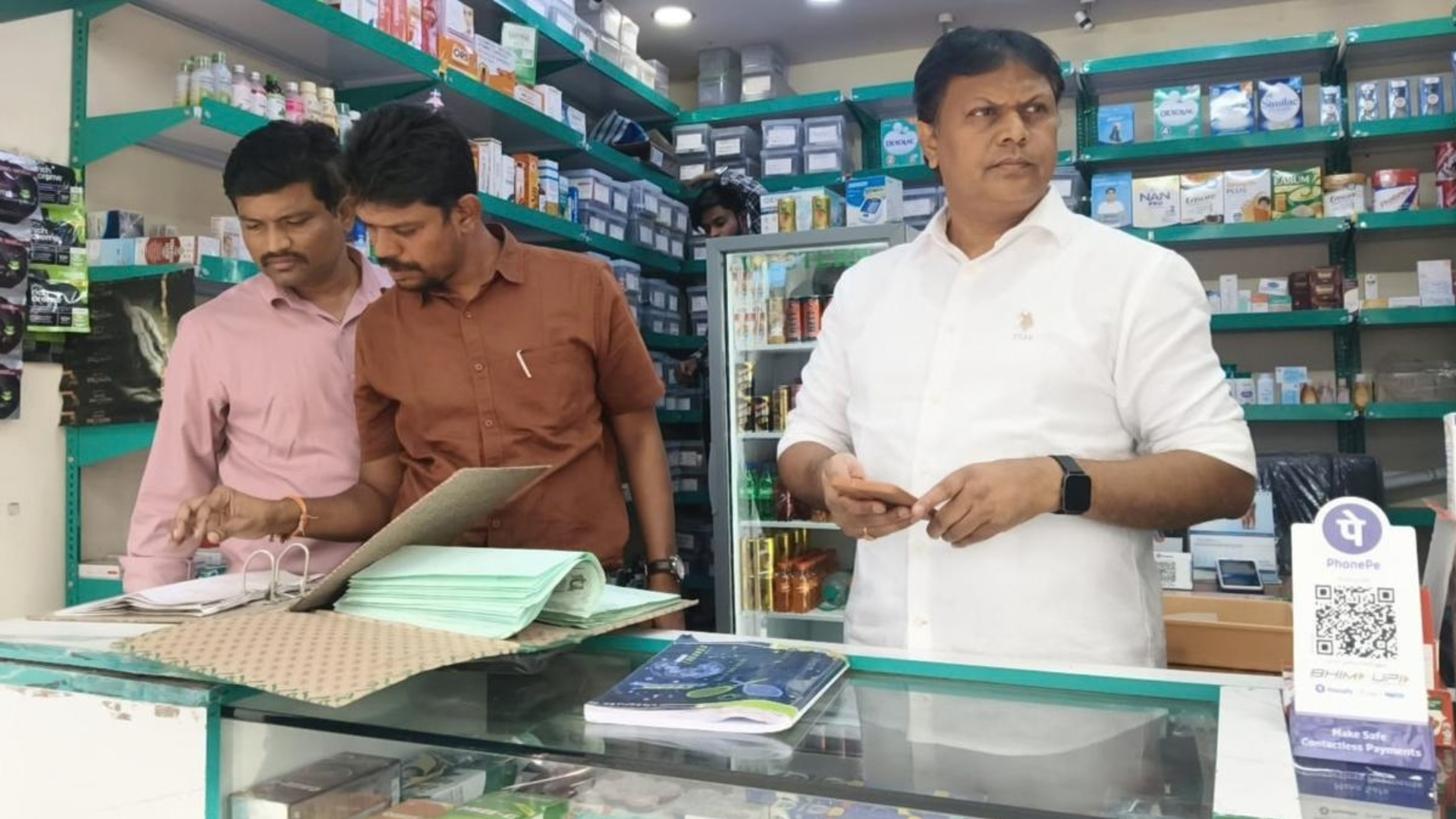 Enforcement officials inspect pharmacy records during a drive checking compliance in the sale of regulated medicines.