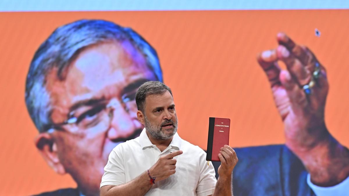 Raahuk Gandhi with mini constitution book in his hand .